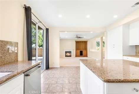 a kitchen with granite countertop sink and refrigerator
