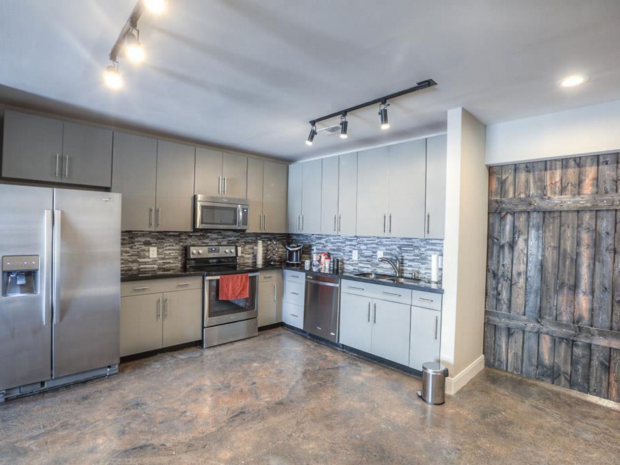 a kitchen with stainless steel appliances granite countertop a refrigerator and a stove top oven