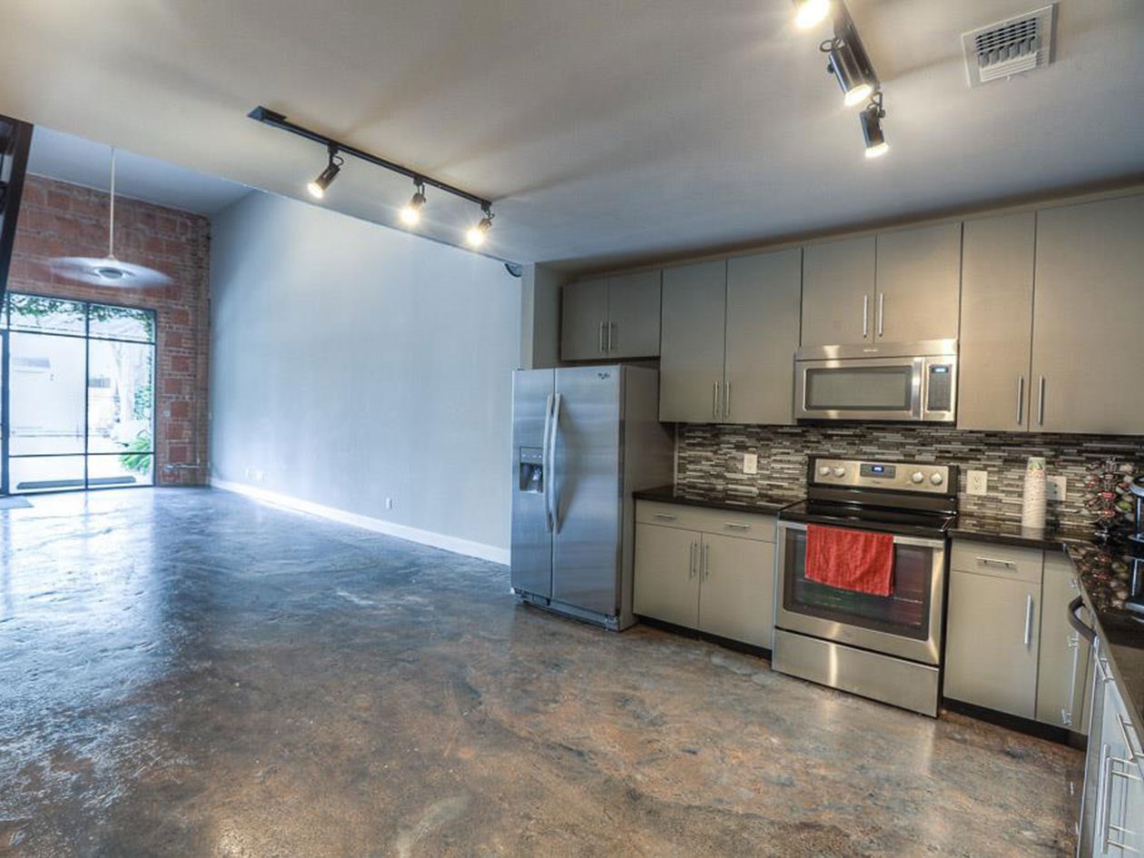 1601 West Webster Street, Unit 11 Houston, TX 77019 - Photo 12 of 26 a kitchen with stainless steel appliances granite countertop a refrigerator a stove and a sink with wooden floor