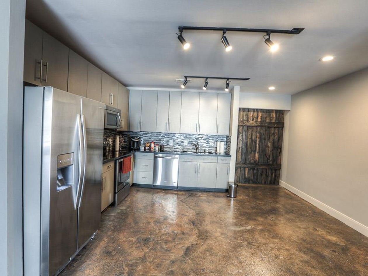 1601 West Webster Street, Unit 11 Houston, TX 77019 - Photo 6 of 26 a large kitchen with stainless steel appliances kitchen island granite countertop a refrigerator and a sink