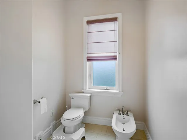 a bathroom with a toilet a sink and a large mirror