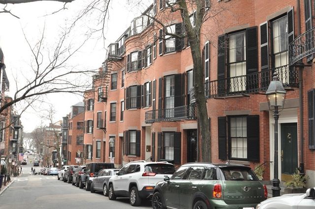 a couple of cars parked in front of brick building