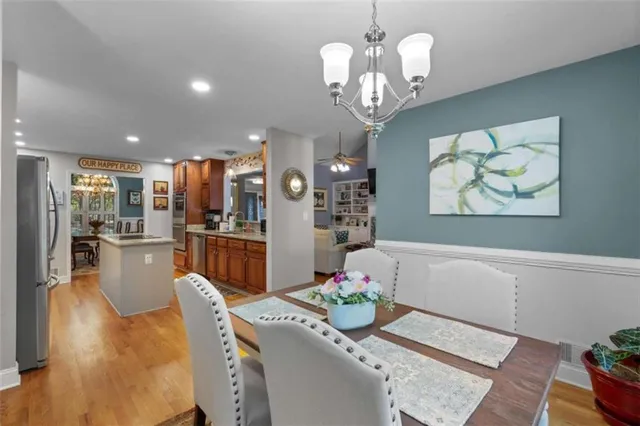 a dining room with furniture a kitchen and chandelier