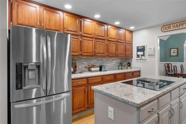 a kitchen with stainless steel appliances granite countertop a refrigerator a sink and a stove