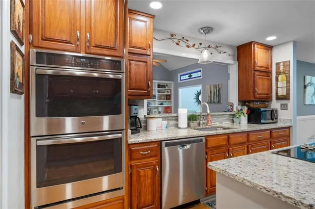 a kitchen with granite countertop stainless steel appliances and wooden cabinets