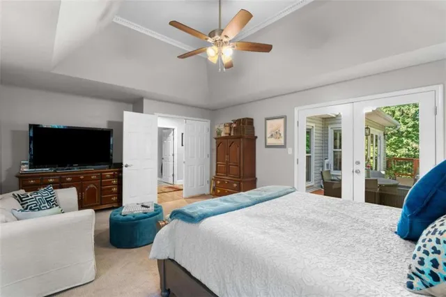 a bedroom with a large bed a flat screen tv and a couch