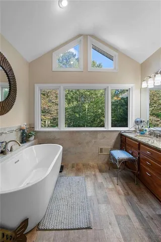 a bathroom with a large tub a sink and a large window