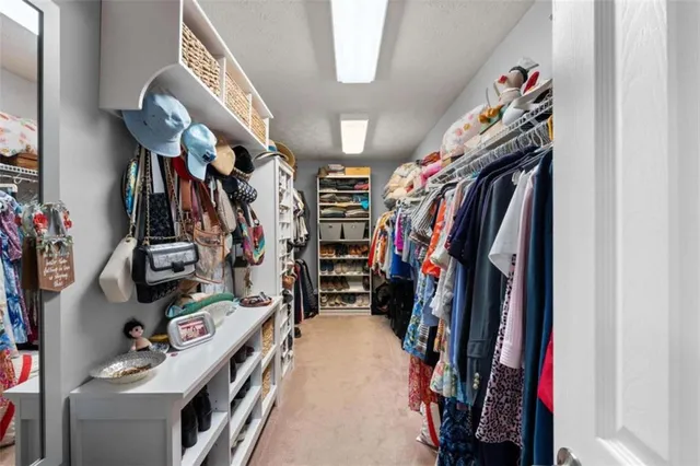 a view of walk in closet with clothes