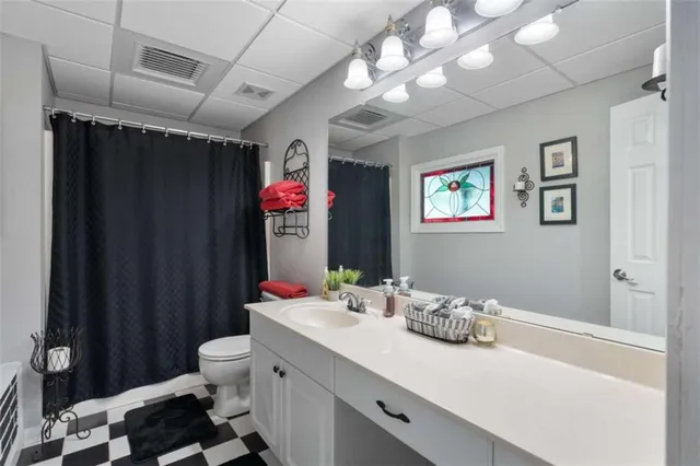 a bathroom with a sink vanity mirror and toilet
