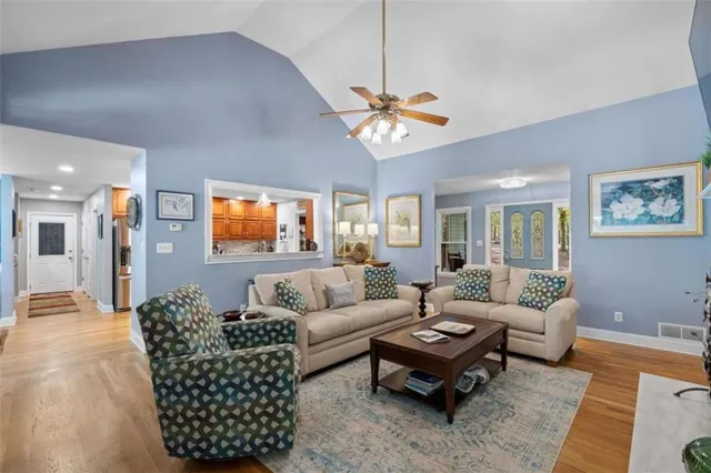 a living room with furniture a ceiling fan and a rug
