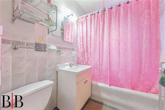 a bathroom with a sink a toilet and shower curtain
