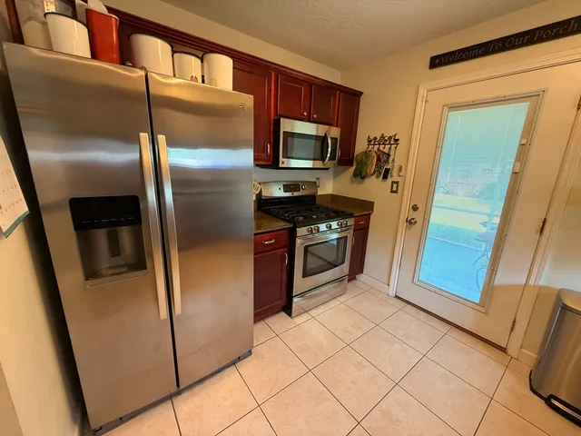 a kitchen with stainless steel appliances granite countertop a refrigerator and a stove