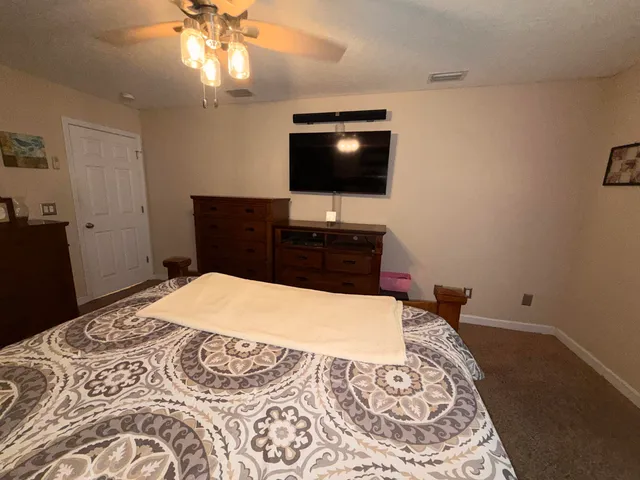 a spacious bedroom with a bed and a chandelier
