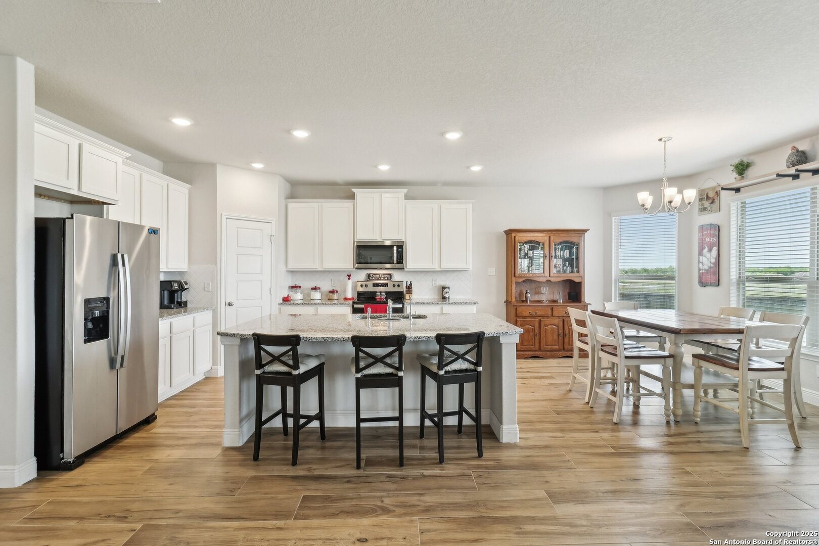 402 Devnet Cibolo, TX 78108 - Photo 8 of 32 a kitchen with stainless steel appliances a dining table chairs stove refrigerator and cabinets
