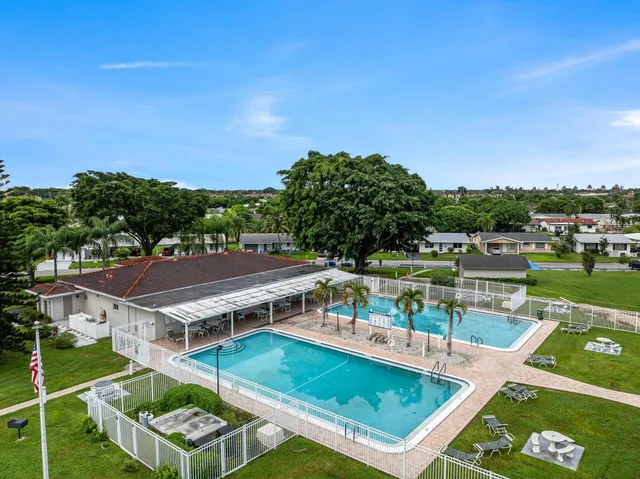 a view of a swimming pool with lounge chairs in front of a house