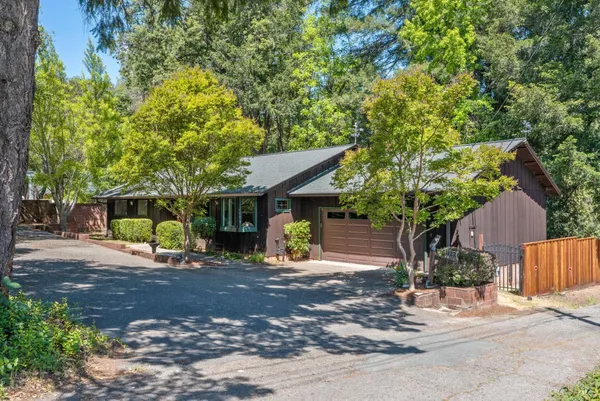a front view of a house with a tree