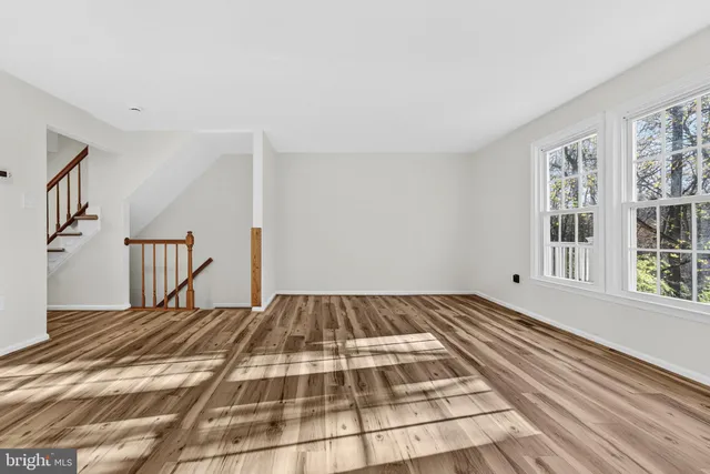 a view of a room with wooden floor and windows