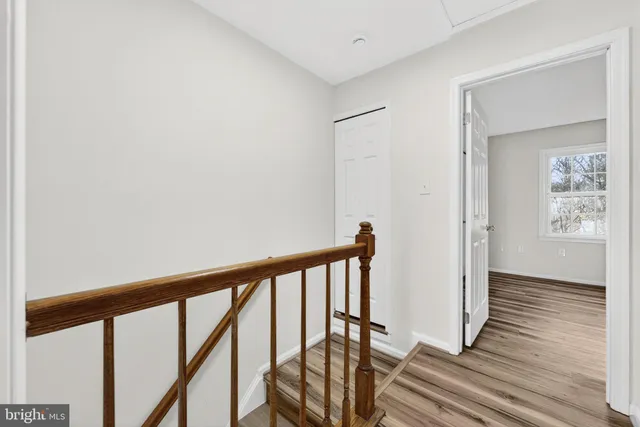 a view of a hallway with wooden floor and staircase