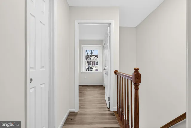 a view of a hallway with wooden floor and closet