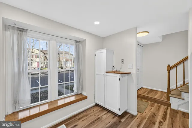 a view of a hallway with wooden floor and cabinet