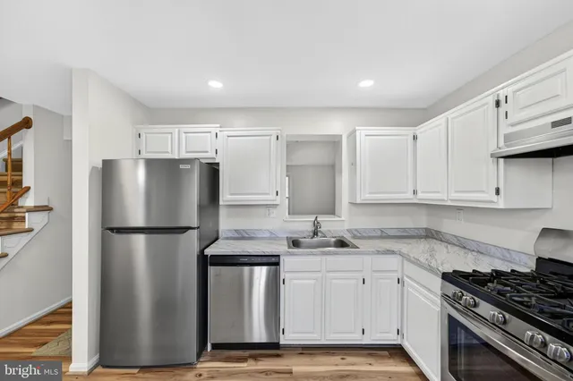 a kitchen with white cabinets and stainless steel appliances