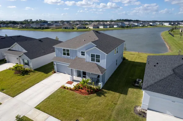 an aerial view of a house with a garden and lake view