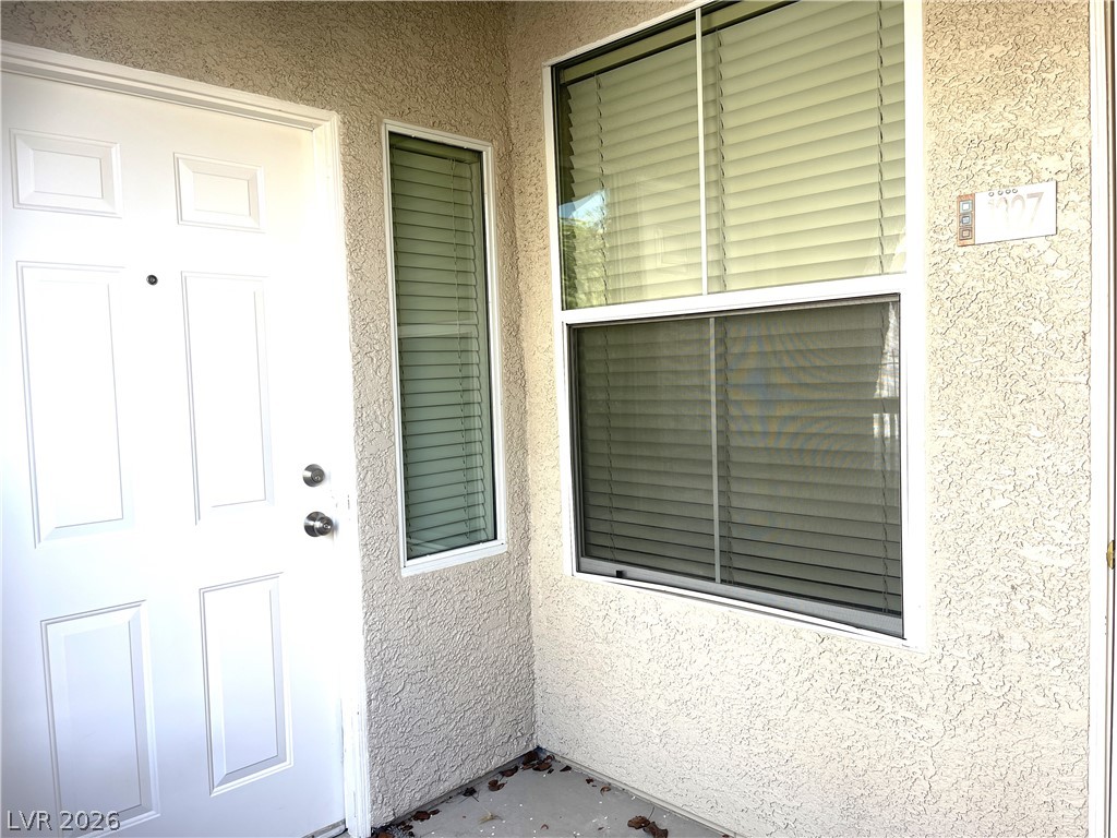 10001 Peace Way, Unit 1327 Las Vegas, NV 89147 - Photo 4 of 21 A welcoming entry features a white paneled door alongside large windows, offering natural illumination.