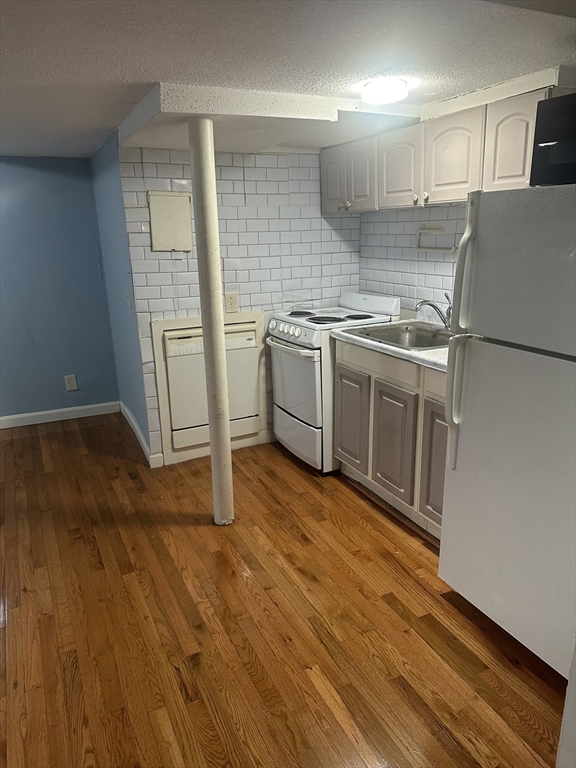 57 Brighton Avenue, Unit B Boston, MA 02134 - Photo 4 of 17 a kitchen with granite countertop a sink and a stove top oven