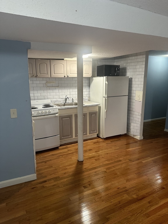 57 Brighton Avenue, Unit B Boston, MA 02134 - Photo 6 of 17 a kitchen with stainless steel appliances granite countertop a refrigerator and a stove top oven