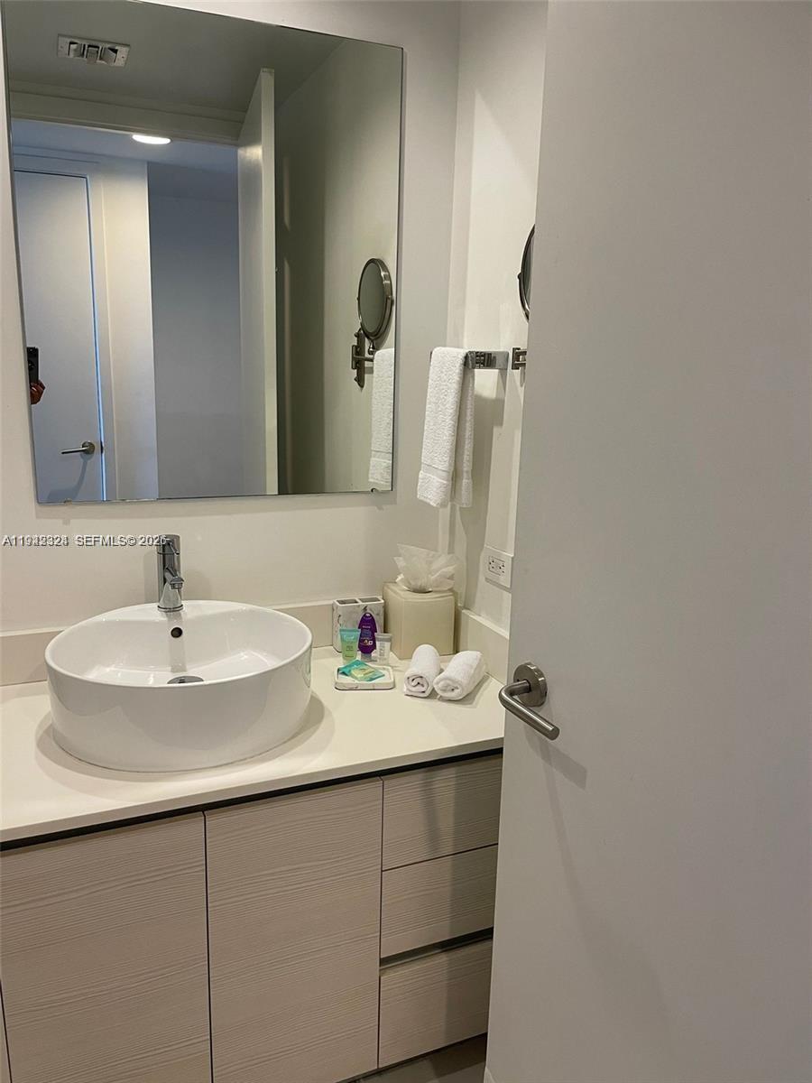 2602 East Hallandale Beach Boulevard, Unit R2508 Hallandale Beach, FL 33009 - Photo 12 of 31 a bathroom with a sink and a mirror