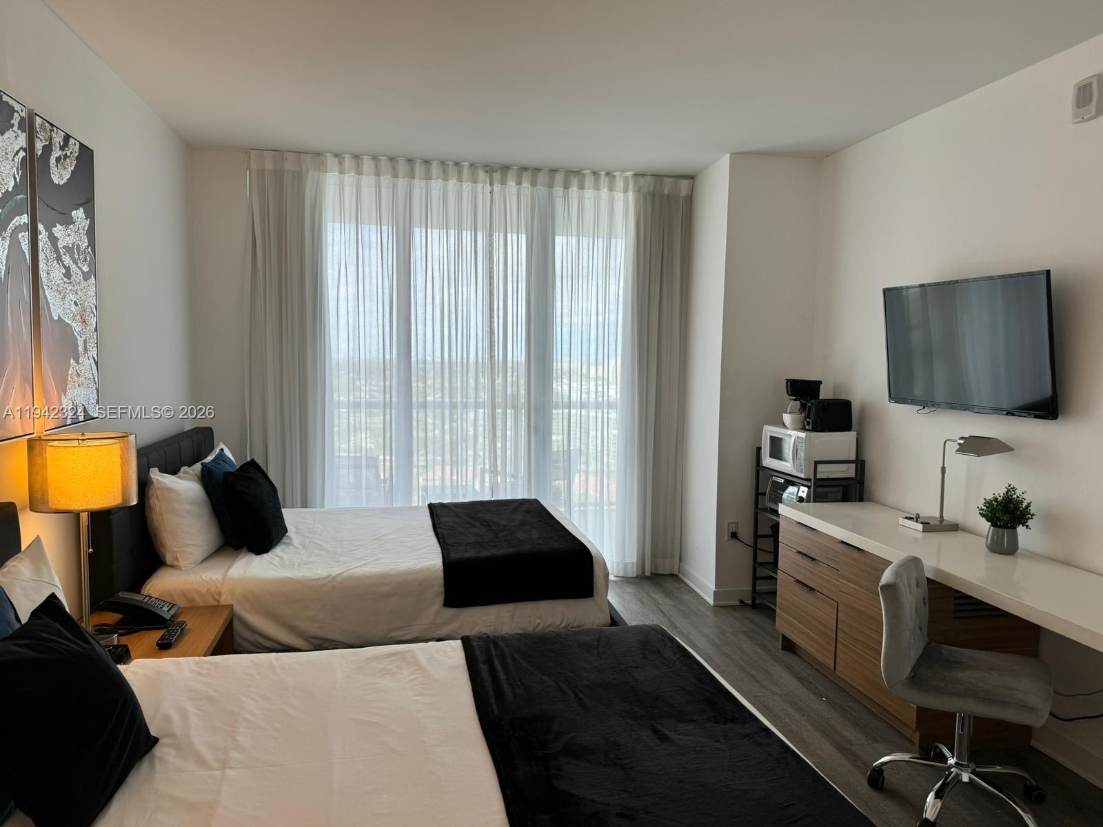 2602 East Hallandale Beach Boulevard, Unit R2508 Hallandale Beach, FL 33009 - Photo 16 of 31 a living room with furniture and a flat screen tv