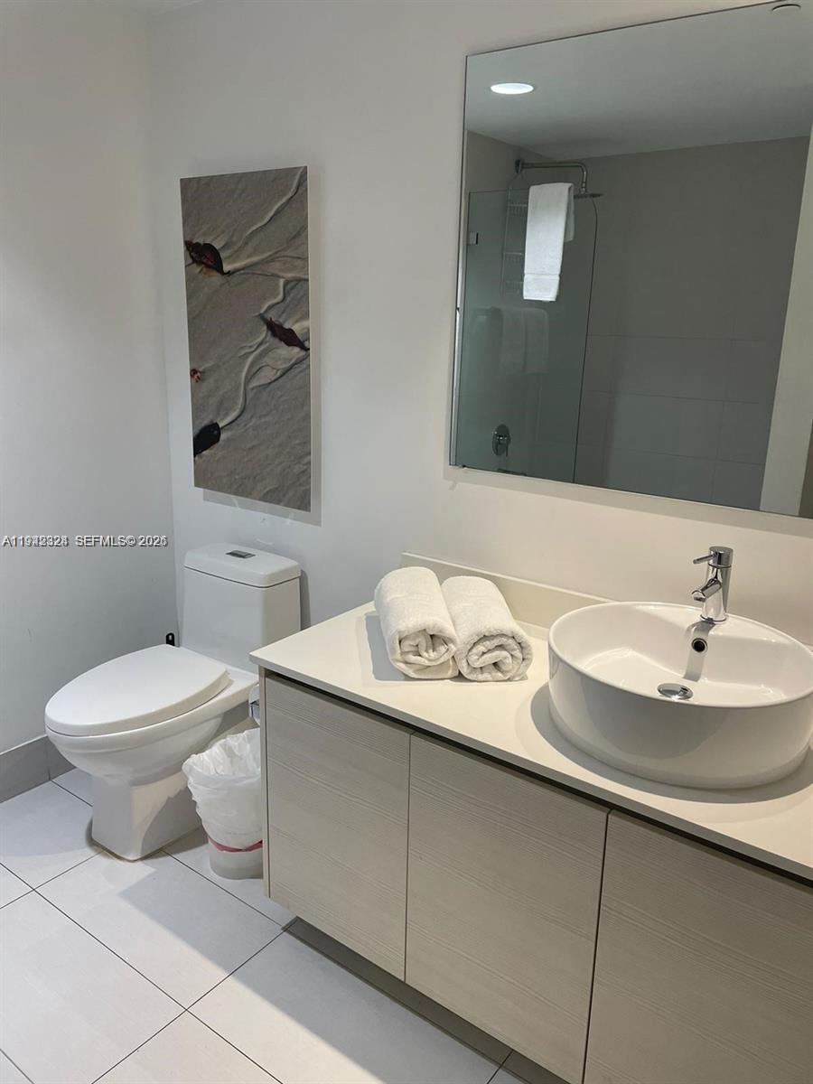2602 East Hallandale Beach Boulevard, Unit R2508 Hallandale Beach, FL 33009 - Photo 17 of 31 a bathroom with a toilet sink and mirror