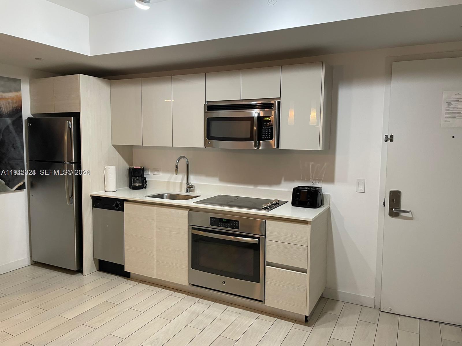 2602 East Hallandale Beach Boulevard, Unit R2508 Hallandale Beach, FL 33009 - Photo 6 of 31 a kitchen with a stove and a microwave