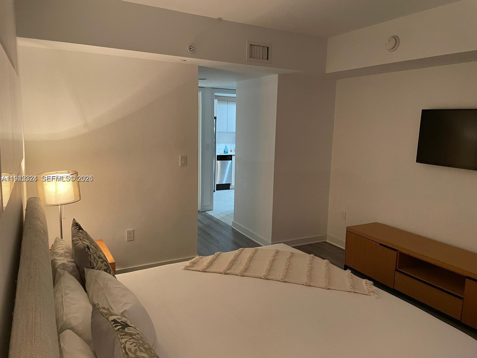 2602 East Hallandale Beach Boulevard, Unit R2508 Hallandale Beach, FL 33009 - Photo 7 of 31 a bedroom with a bed and a tv