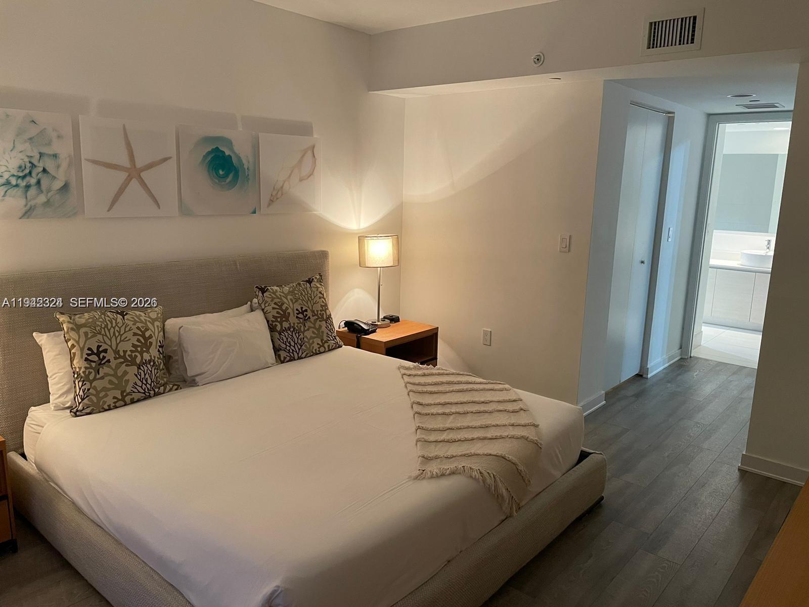 2602 East Hallandale Beach Boulevard, Unit R2508 Hallandale Beach, FL 33009 - Photo 8 of 31 a large bed sitting in a bedroom next to a window