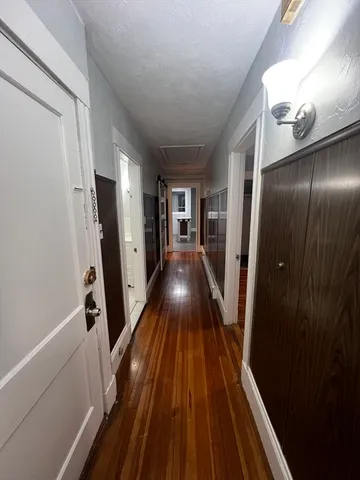 a view of a hallway with wooden floor