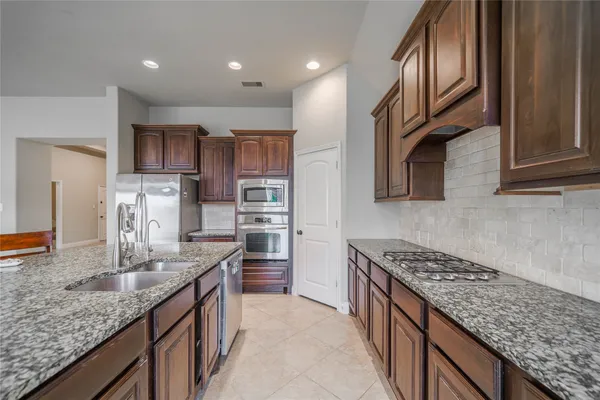 a kitchen with stainless steel appliances granite countertop a sink stove and refrigerator