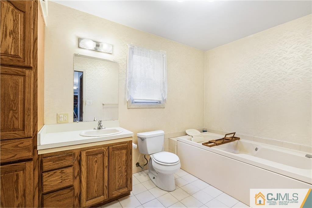 151 East Cliff Road Colonia, NJ 07067 - Photo 17 of 29 a bathroom with a sink a toilet and mirror