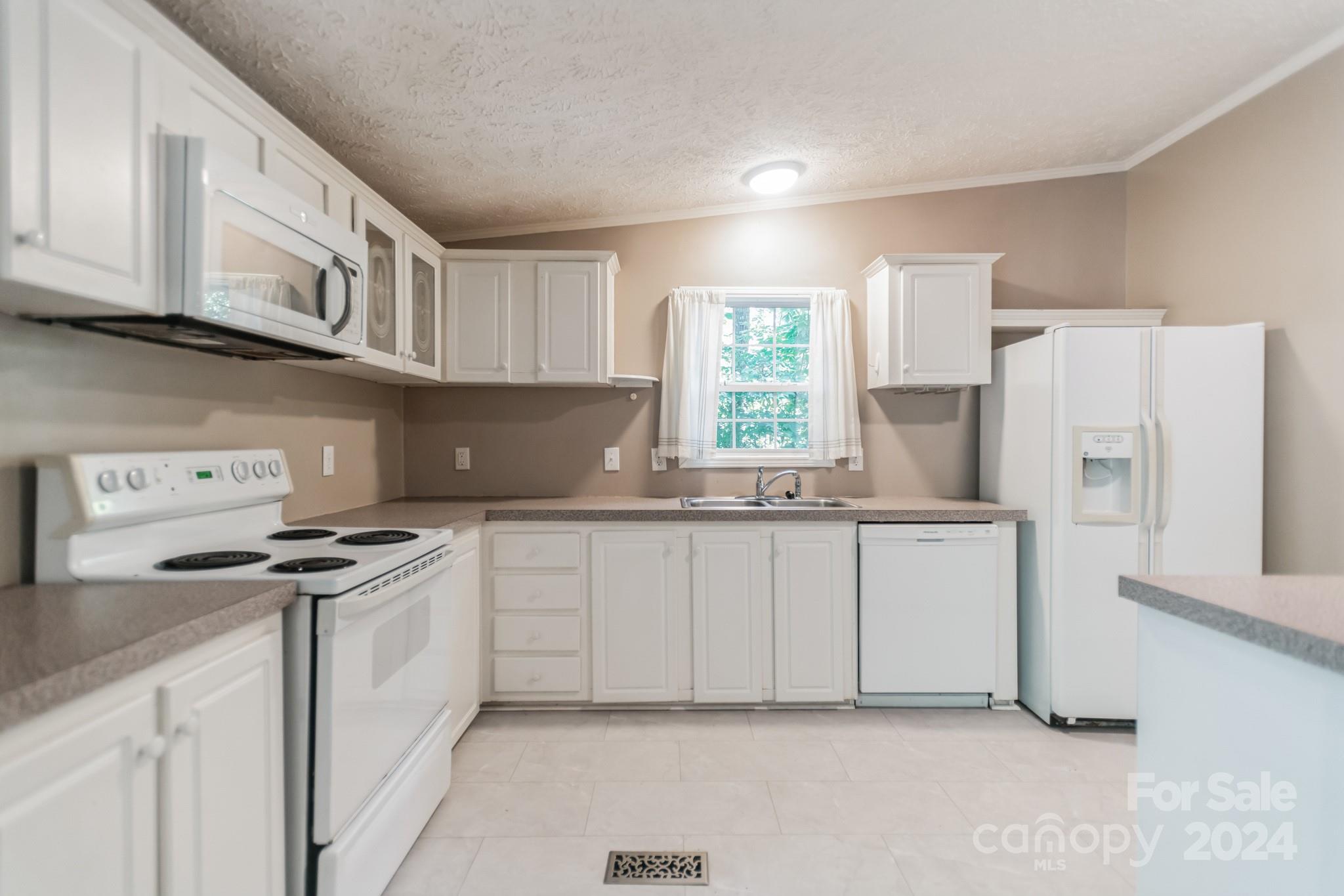 104 Cane Crest Circle Fairview, NC 28730 - Photo 6 of 29 a kitchen with stainless steel appliances granite countertop a refrigerator sink and white cabinets