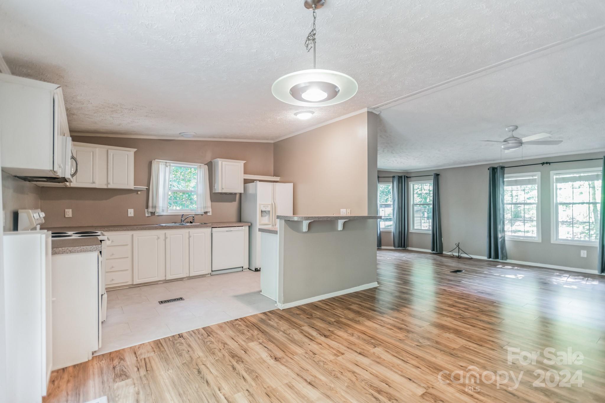 104 Cane Crest Circle Fairview, NC 28730 - Photo 7 of 29 a large kitchen with cabinets wooden floor and stainless steel appliances