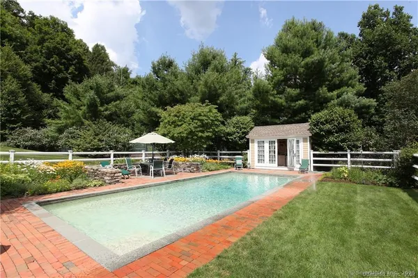 a view of a tennis ground with large trees