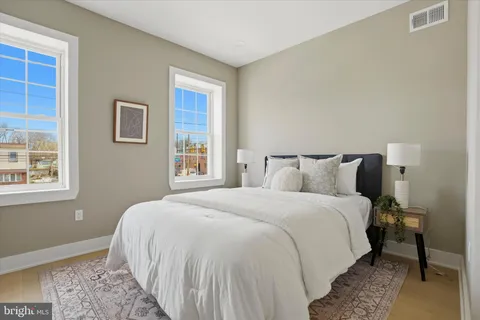a bedroom with a bed and wooden floor