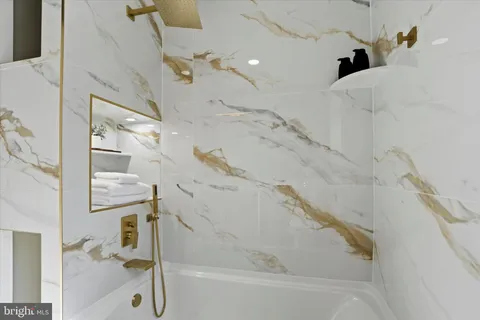 a bathroom with a granite countertop toilet sink and mirror