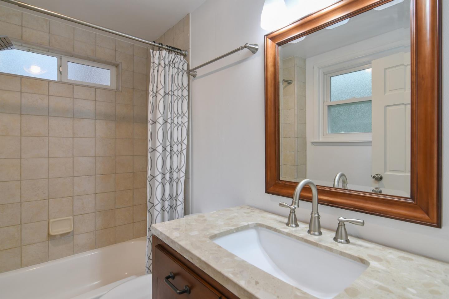 144 Eagle Crest Drive Scotts Valley, CA 95066 - Photo 17 of 28 a bathroom with a granite countertop sink a mirror and shower