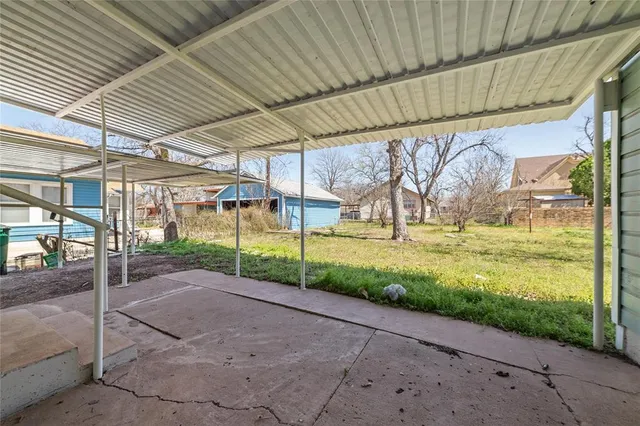a view of a house with backyard and tree