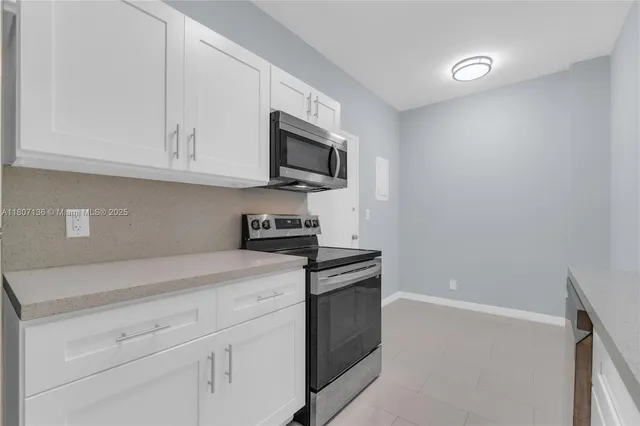 a kitchen with stainless steel appliances granite countertop white cabinets and a granite counter tops