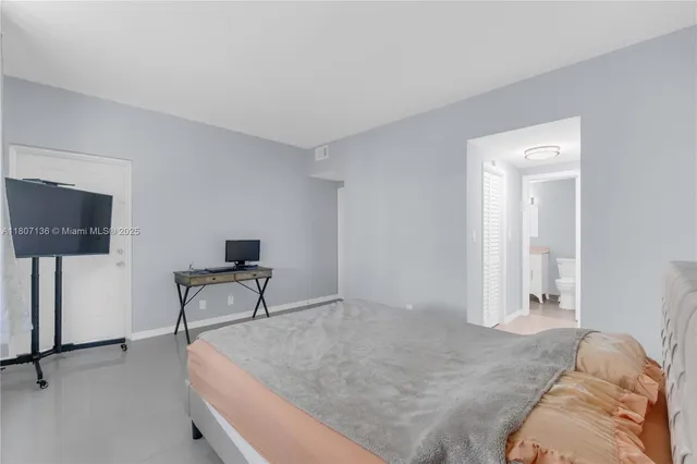 a bedroom with a bed and a television