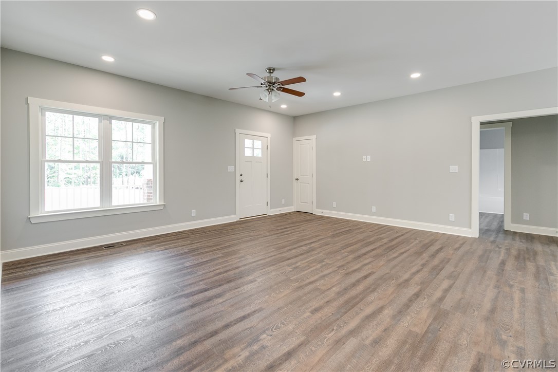 354 Buckner Road Bumpass, VA 23024 - Photo 8 of 22 an empty room with wooden floor chandelier fan and windows