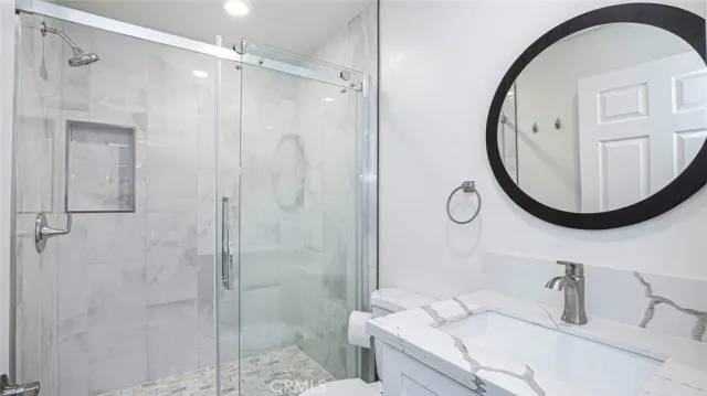 a bathroom with a granite countertop sink mirror and shower