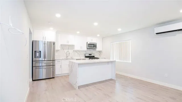 a kitchen with stainless steel appliances a refrigerator and a stove top oven